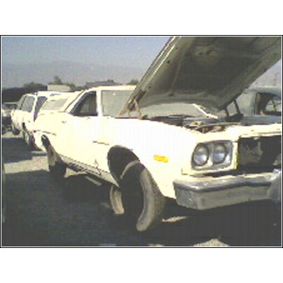 1973 Ford Ranchero - White 1977 Ford Ranchero in a parts yard, hood up, showing engine bay.