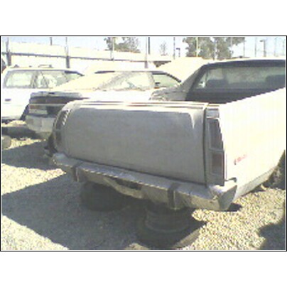 1973 Ford Ranchero - This vehicle appears to be a pickup truck, possibly a Ford Ranchero, in a junkyard setting.