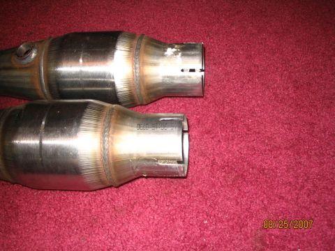 2007 Ford Mustang - Two catalytic converters are shown, with one displaying part numbers and a date stamp of 08/25/2007.