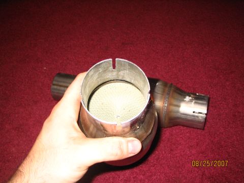 2007 Ford Mustang - Close-up of a catalytic converter part held in hand, with a date stamp visible.