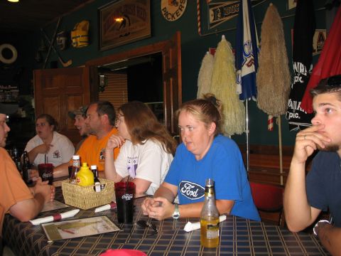 1995 Ford C-350 (Centurion Conversions) - People gather around a table in a bar, with drinks and condiments visible.