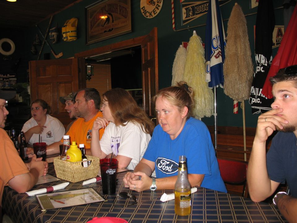 Woman in blue Ford shirt at table with drinks and condiments
