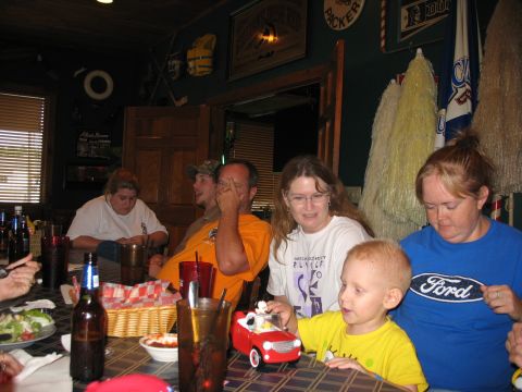 1995 Ford C-350 (Centurion Conversions) - A group of people are gathered around a table, with a child playing with a toy car.