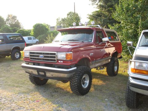 1995 Ford C-350 (Centurion Conversions) - This lifted red Ford Bronco has a custom light bar and off-road tires.