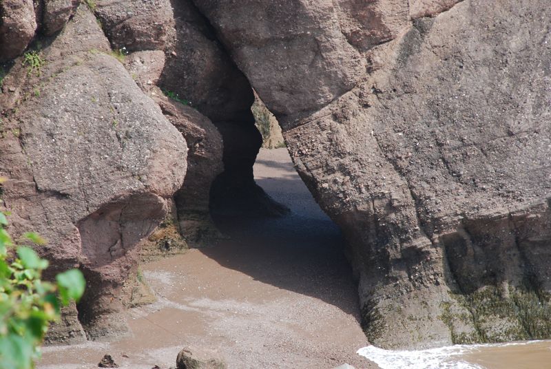 Coastal rock formations with a sandy beach and ocean waves