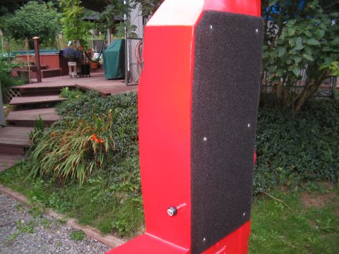 1989 Ford Bronco - A close-up of a red structure with black padding is visible in an outdoor setting.