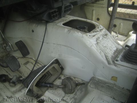 1987 Suzuki Samurai - Interior view of a 1987 Suzuki Samurai, focusing on the floor pan and transmission tunnel area.
