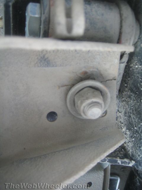 1987 Suzuki Samurai - A close-up view shows a cracked metal bracket secured by a bolt and washer, suggesting a potential structural issue.