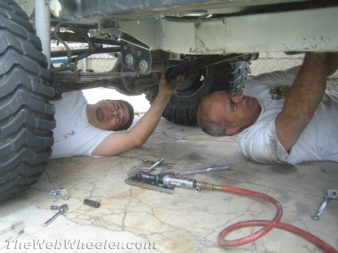 1987 Suzuki Samurai - Mechanics are performing maintenance on the suspension and drivetrain of a vehicle.