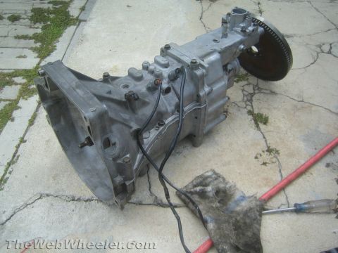 1987 Suzuki Samurai - Transmission assembly with bell housing and flywheel, likely removed from a vehicle for service or replacement.