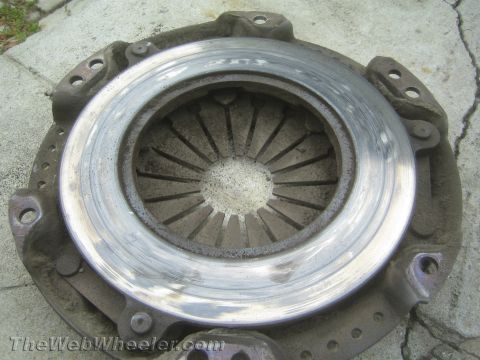1987 Suzuki Samurai - A close-up view of a used clutch pressure plate, showing signs of wear on the friction surface.