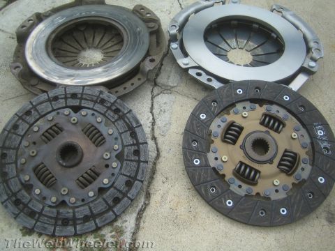 1987 Suzuki Samurai - Two clutch assemblies are displayed on a concrete surface, likely for comparison or sale.