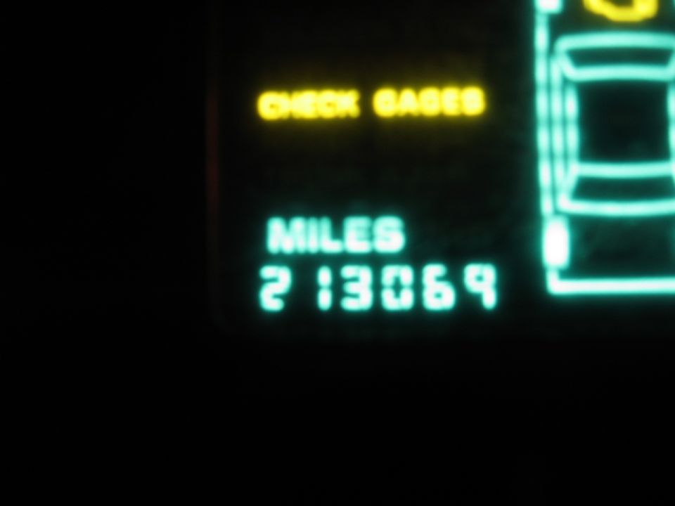Digital dashboard showing "CHECK GAGES" and "MILES 213069" with a schematic car