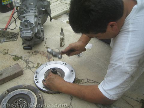 1987 Suzuki Samurai - A person works on a transmission and clutch assembly, with a bottle of gear oil visible in the background.