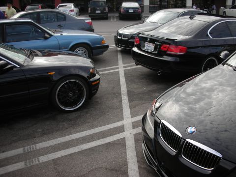 1998 Ford Crown Victoria - Multiple cars, including BMWs and a blue sedan, are parked together in a lot.