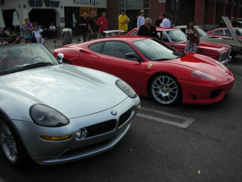 1998 Ford Crown Victoria - A red Ferrari 360 Modena is parked alongside a silver BMW Z8 at a car meet.