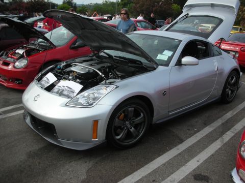 1998 Ford Crown Victoria - A silver Nissan 350Z is displayed with its engine and trunk open at an outdoor car meet.
