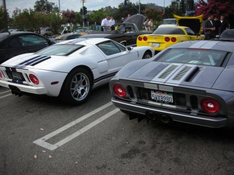 1998 Ford Crown Victoria - Two Ford GT sports cars are parked side-by-side in a parking lot, with other vehicles and people in the background.