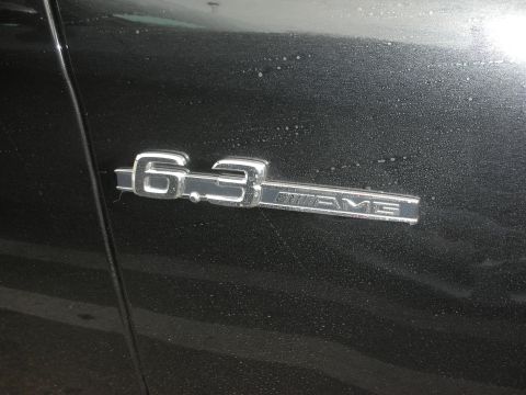 1998 Ford Crown Victoria - Close-up of a chrome 6.3 AMG badge affixed to the side of a dark-colored vehicle.