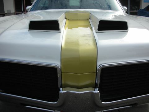 1998 Ford Crown Victoria - A white car with a yellow stripe and prominent air scoops on the hood is shown from the front.