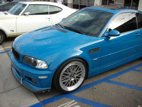 1998 Ford Crown Victoria - A blue BMW coupe is parked in a parking spot next to a white classic car.