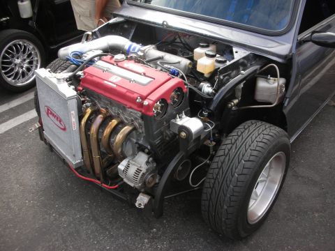 1998 Ford Crown Victoria - Custom engine swap in a vehicle's engine bay, a red Honda engine and aftermarket parts.