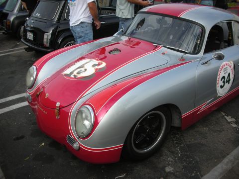1998 Ford Crown Victoria - A silver and red Porsche 356 is parked next to other vehicles, displaying racing numbers.