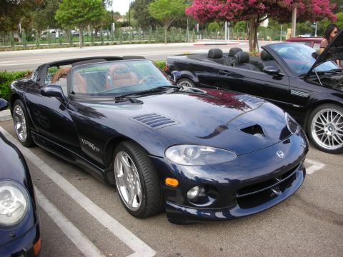 1998 Ford Crown Victoria - A dark blue convertible sports car, possibly a Dodge Viper, parked at a meet.