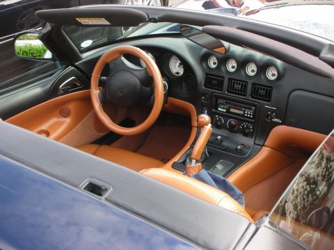 1998 Ford Crown Victoria - The interior of a convertible shows tan leather seats and dashboard accents, with a manual transmission shifter in the center.