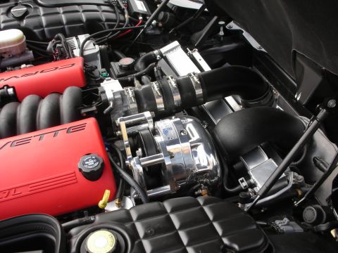 1998 Ford Crown Victoria - Close-up view of a supercharged engine, red valve covers with 'CORVETTE' branding.