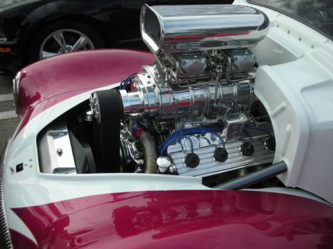 1998 Ford Crown Victoria - Close-up of a highly polished V8 engine with a prominent supercharger, parked next to another vehicle.