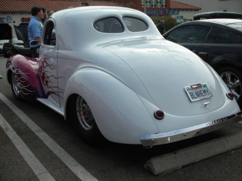 1998 Ford Crown Victoria - A custom hot rod coupe with flame graphics is parked in a lot, with another vehicle visible to its right.