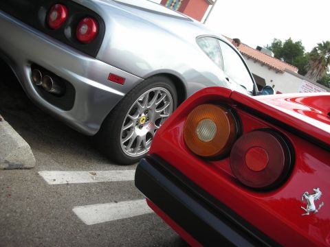 1998 Ford Crown Victoria - Two Ferraris, one red and one silver, are parked close together, with a focus on their rear ends.