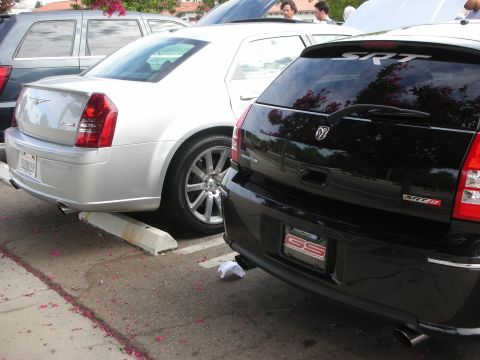 1998 Ford Crown Victoria - Two performance sedans, a black Dodge Magnum SRT8 and a silver Chrysler 300, are parked side-by-side.