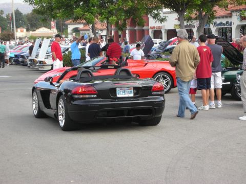 1998 Ford Crown Victoria - A black convertible sports car is seen from the rear at a car meet event.