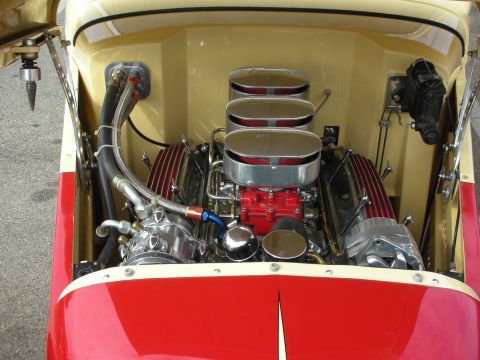1998 Ford Crown Victoria - The engine compartment of a custom car features a powerful V8 engine with multiple carburetors and polished components.