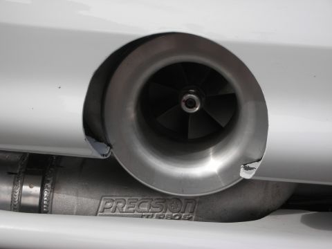 1998 Ford Crown Victoria - A close-up view of a turbocharger exhaust outlet, showing the 'PRECISION TURBOS' branding on the connected piping.