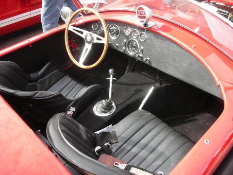1998 Ford Crown Victoria - Interior view of a red sports car, showing seats, steering wheel, and dashboard instruments.