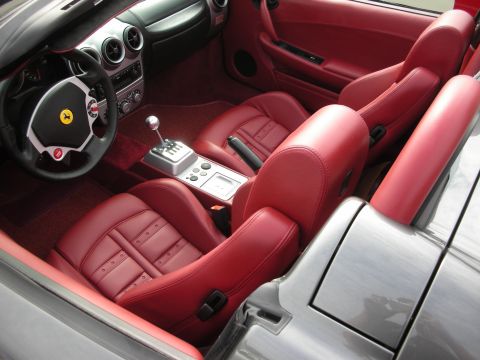 1998 Ford Crown Victoria - The striking red leather interior of a convertible features a gated shifter and sporty bucket seats.