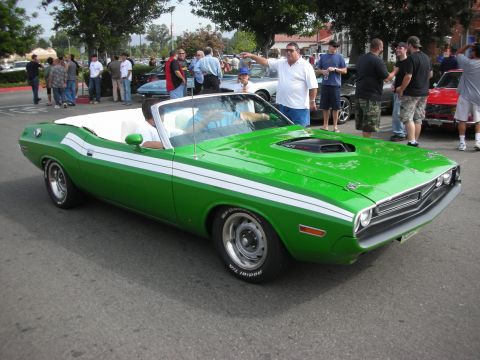 1998 Ford Crown Victoria - A group of people gather around a bright green convertible muscle car at an outdoor event.