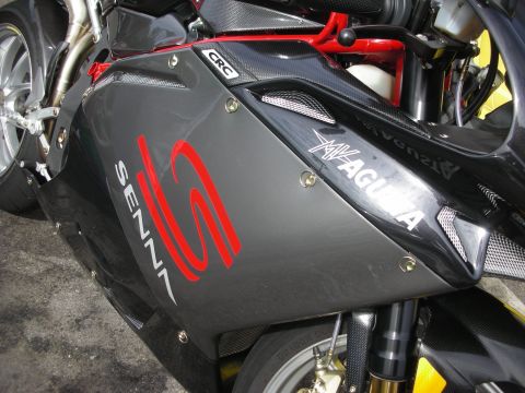 1998 Ford Crown Victoria - A close-up view of an MV Agusta motorcycle's side fairing, displaying prominent 'SENNA' and 'MV AGUSTA' branding.