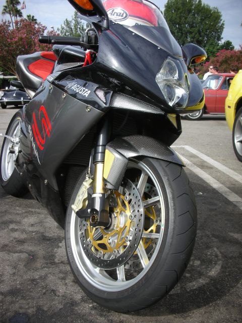 1998 Ford Crown Victoria - A black MV Agusta motorcycle is parked at a coffee meet, with other vehicles visible in the background.