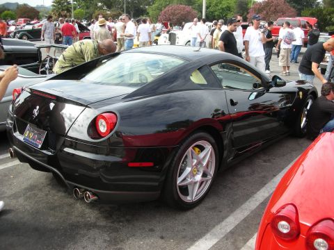 1998 Ford Crown Victoria - A black Ferrari 599 GTB Fiorano is parked at an outdoor car meet, with a red Ferrari partially visible in the foreground.