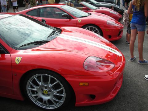 1998 Ford Crown Victoria - A line of red Ferraris are parked together, with people standing nearby.