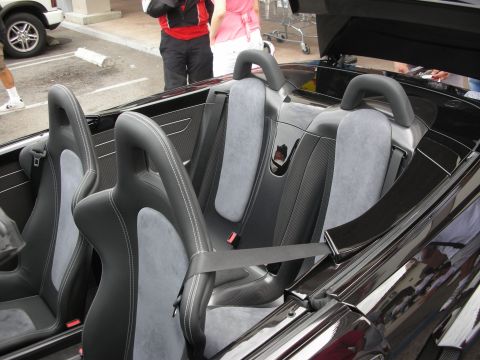 1998 Ford Crown Victoria - The interior of a black convertible sports car features bucket seats with grey suede inserts and prominent roll bars.
