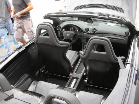 1998 Ford Crown Victoria - The interior of a black convertible sports car is visible, showing its racing-style seats and dashboard.