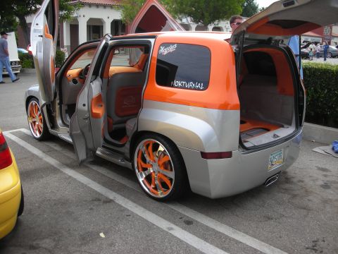 1998 Ford Crown Victoria - Modified Chevrolet HHR with custom doors and vibrant orange interior accents is parked at an event.
