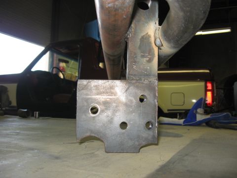 1991 Ford Bronco - A close-up of a custom metal bumper bracket is shown, with a yellow and brown Ford Bronco visible in the background.