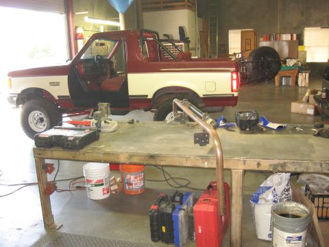 1991 Ford Bronco - Workshop scene with a 1991 Ford Bronco and various tools laid out on a workbench.