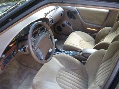 1992 Ford Crown Victoria - The interior of a 1992 Ford Crown Victoria shows tan velour seats, wood grain trim, and the dashboard.